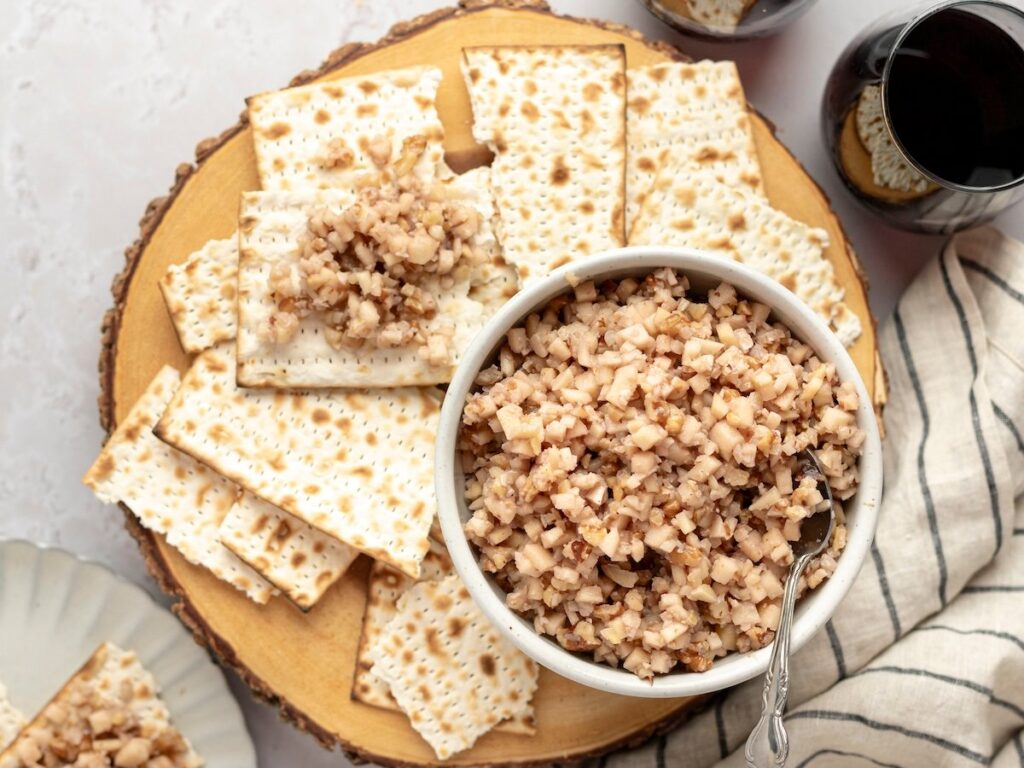white bowl of charoset surrounded by pieces of matzo 