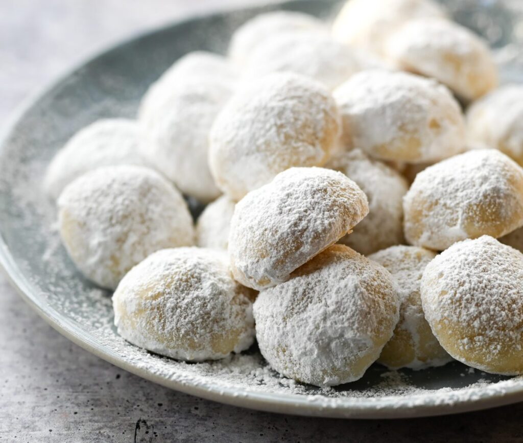 Snowball cookies piled on a plate.