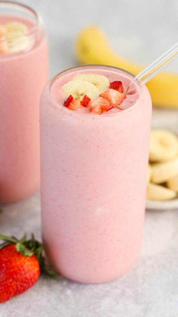 clear glass with strawberry banana topped with diced strawberry and banana