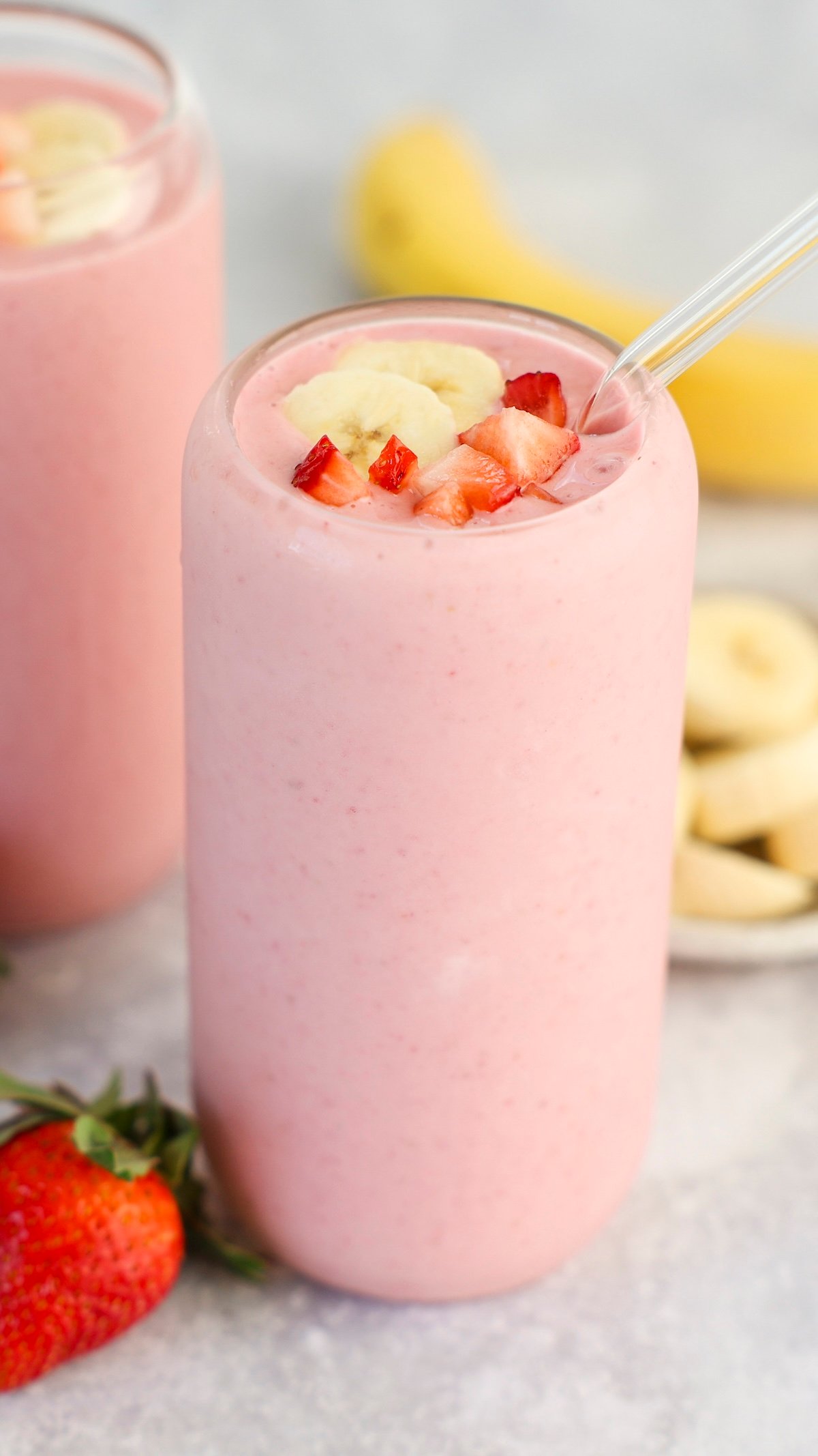 clear glass with strawberry banana topped with diced strawberry and banana